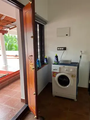 a laundry room with a washing machine and a window at Do not book in Kāladi