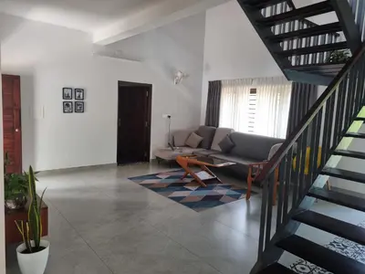 a living room with a couch and a staircase at Eden Villa in Meenangadi