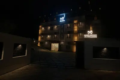 a lit up building with adq sign at night at DQ Premium Apartments in Ernakulam