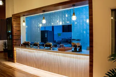 a bar in a restaurant with a blue wall at DQ Premium Apartments in Ernakulam