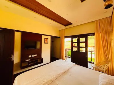 a bedroom with a bed and a tv and a window at Vaca Vibes Resorts in Koroth