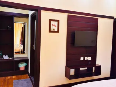 a bedroom with a wall with a flat screen tv at Vaca Vibes Resorts in Koroth