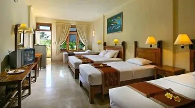 a hotel room with three beds and a television at Suvarna Residency in Mysore