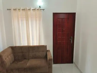 a living room with a couch and a wooden door at Little Villa East Fort in Trichūr