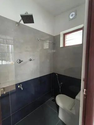 a bathroom with a toilet and a glass shower at Little Villa East Fort in Trichūr