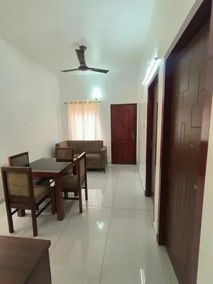 a living room with a table and a couch at Little Villa East Fort in Trichūr
