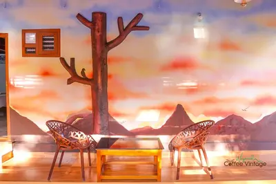 two chairs and a table in front of a wall at Wayanad Coffee Vintage in Wayanad
