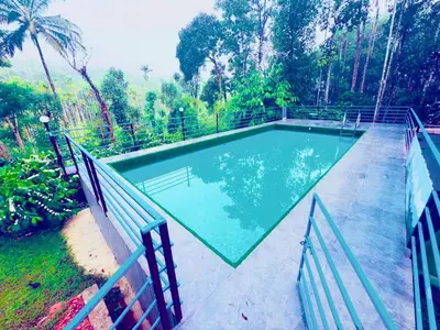 a swimming pool with a fence around it at Wayanad Coffee Vintage in Wayanad