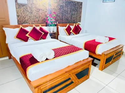 two beds in a room with red and white pillows at Wayanad Coffee Vintage in Wayanad