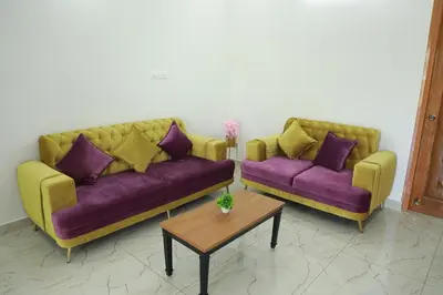 two couches in a living room with purple and yellow at Maitree Serenity Farm Stay