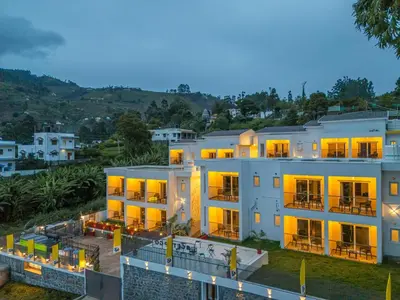 a large white building with its lights on at The Hosteller Kodaikanal in Kodaikānāl