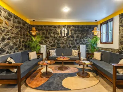 a restaurant with couches and tables in a room at The Hosteller Kodaikanal in Kodaikānāl