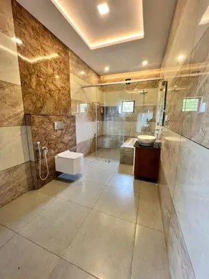 a large bathroom with a shower and a sink at Riverside Luxury Private Pool Villa in Athirappilly in Athirappally