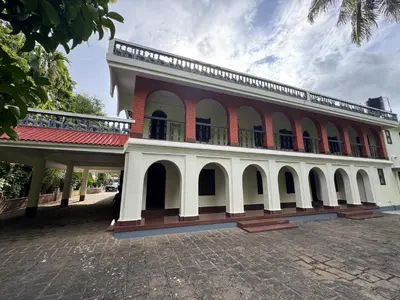 a building with a balcony on top of it at Kerala Heritage Private Pool Villa - Tharavad in Māla