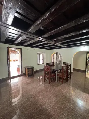 a room with a table and chairs in it at Kerala Heritage Private Pool Villa - Tharavad in Māla