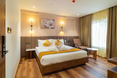 a hotel room with a bed with a flower on it at Senora Suites in Kannur