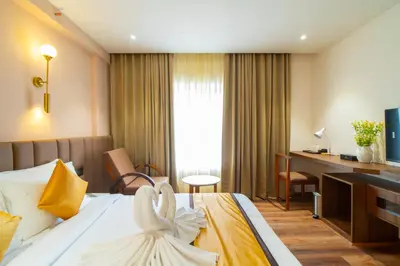a hotel room with a bed and a desk at Senora Suites in Kannur