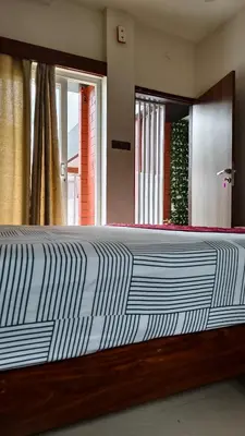 a large bed in a room with a large mirror at Nelleri Residency Managed By Vaishno Hospitality in Iritti
