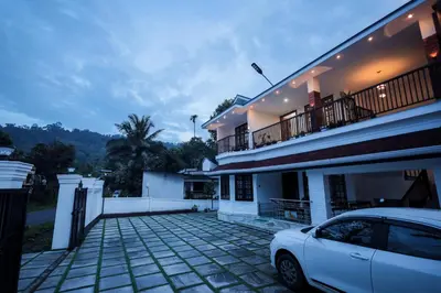 a white car parked in front of a house at Wayanadan Huts Homestay in Sultan Bathery