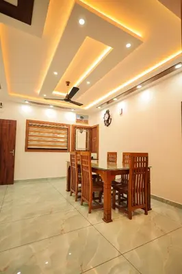 a dining room with a wooden table and chairs at Wayanadan Huts Homestay in Sultan Bathery