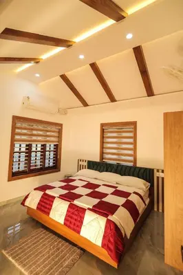 a bedroom with a large bed with a checkered blanket at Wayanadan Huts Homestay in Sultan Bathery