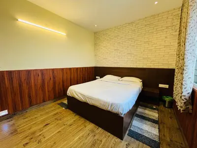 a bedroom with a bed and a brick wall at Away From Home - 7 - Home Stay Ooty, Entire 3BHK Villa in Ooty