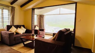 a living room with two couches and a large window at Away From Home - 7 - Home Stay Ooty, Entire 3BHK Villa in Ooty