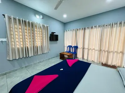 a room with a ping pong table and two blue chairs at Himadri Retreat Wayanad in Kaniyāmbetta