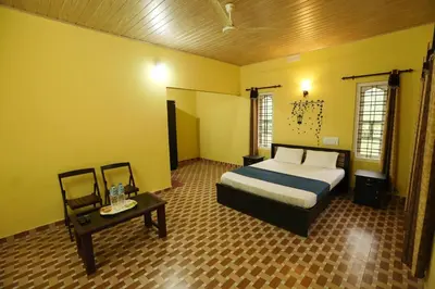 a bedroom with a bed and a table in it at Himadri Retreat Wayanad in Kaniyāmbetta