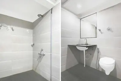 a bathroom with a shower and a toilet and a sink at Townhouse Oak Mysuru Railway Museum in Mysore