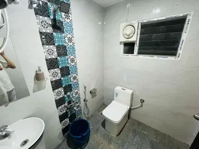 a bathroom with a toilet and a sink at City home-SGH in Mysore