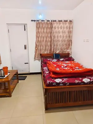 a bedroom with a bed and a window and a door at shambhala homestay in Ooty