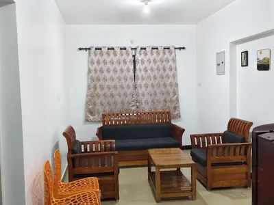 a living room with a couch and chairs at shambhala homestay in Ooty