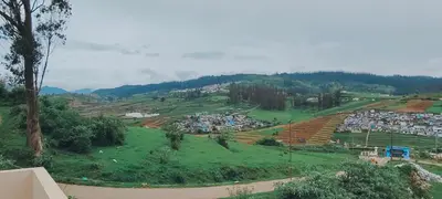 a view of a town on a hill at shambhala homestay in Ooty