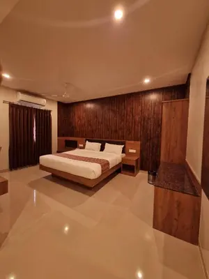 a bedroom with a bed and a wooden wall at Le Royal Suite in Udumalaippettai