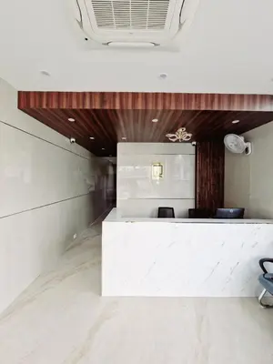 a lobby with a white counter and chairs at Le Royal Suite in Udumalaippettai