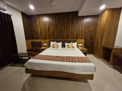 a bedroom with a large bed with wooden walls at Le Royal Suite in Udumalaippettai
