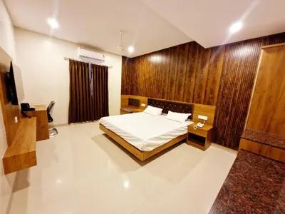 a bedroom with a bed and a television in it at Le Royal Suite in Udumalaippettai