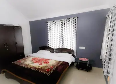 a bedroom with a bed and a blue wall at Maria villa in Ooty