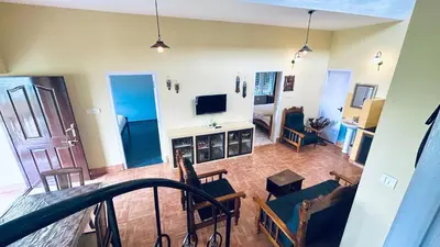 a living room with a couch and a television at Away From Home - 1 - Home Stay Ooty, Entire 3BHK Villa in Ooty