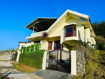 a white house with a black gate in front of it at Away From Home - 1 - Home Stay Ooty, Entire 3BHK Villa in Ooty