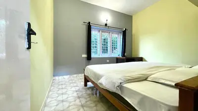 a bedroom with a bed and a window at Away From Home - 1 - Home Stay Ooty, Entire 3BHK Villa in Ooty