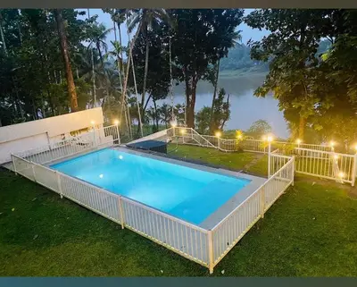 a large swimming pool in the yard of a house at Enchanted Woods in Perumbavoor