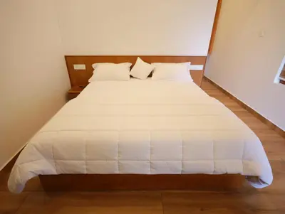 a bed with white sheets and pillows in a room at Enchanted Woods in Perumbavoor