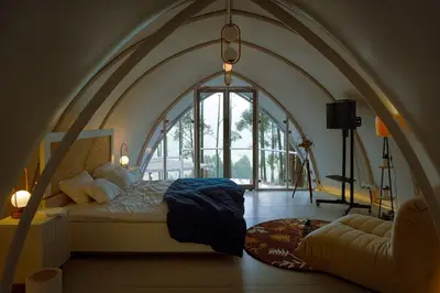 a bedroom with a bed in a room with a large window at Cocoon-coxcargill in Vattavada