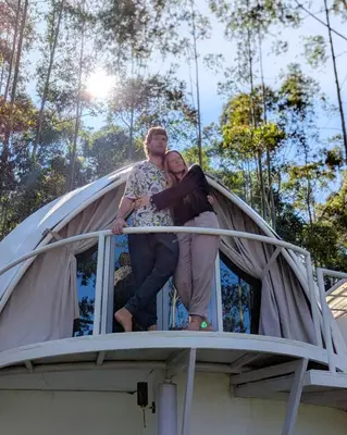 a man and woman sitting on top of a house at Cocoon-coxcargill in Vattavada