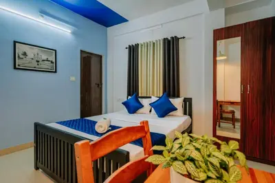 a bedroom with a bed and a chair at Holiday Homes Aluva in Alwaye