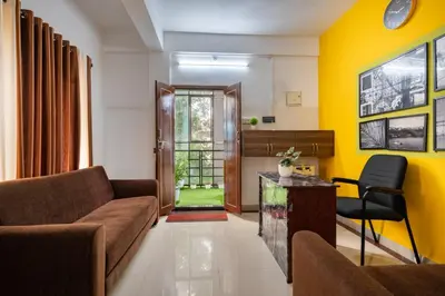 a living room with yellow walls and a couch at Holiday Homes Aluva in Alwaye