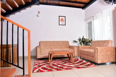 a living room with two chairs and a coffee table at Snow White Wayanad in Wayanad