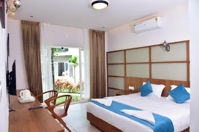 a bedroom with a bed and a desk and a window at Snow White Wayanad in Wayanad